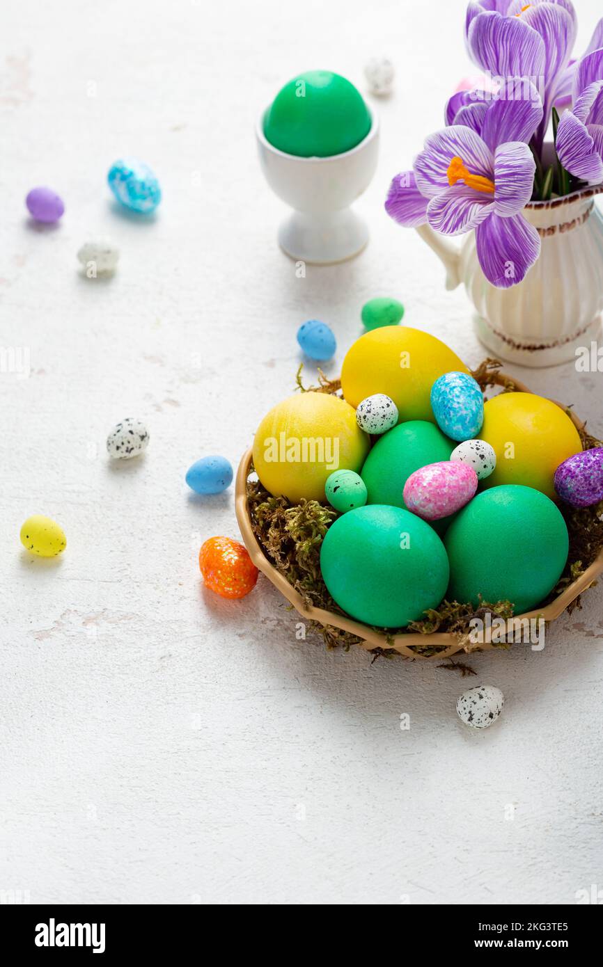 Spring flowers in pitcher Easter background color eggs Stock Photo