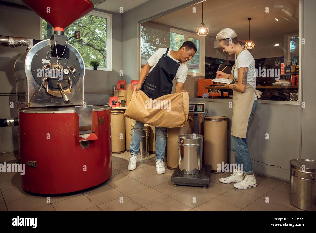 Two people measuring the weight of goods Stock Photo Alamy
