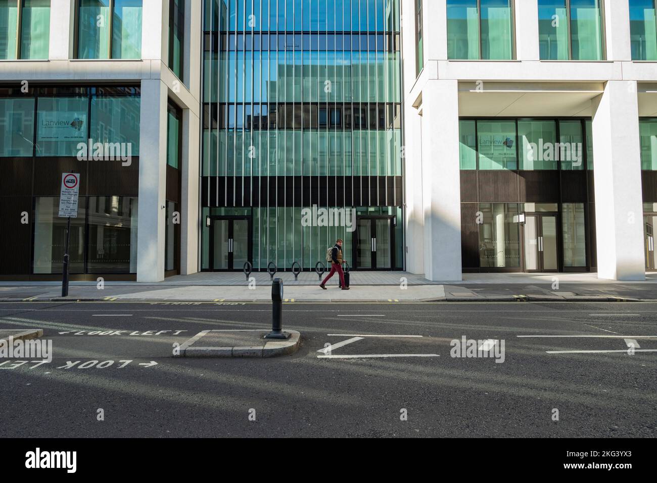 Man with wheeled suitcase walking in Victoria street Stock Photo