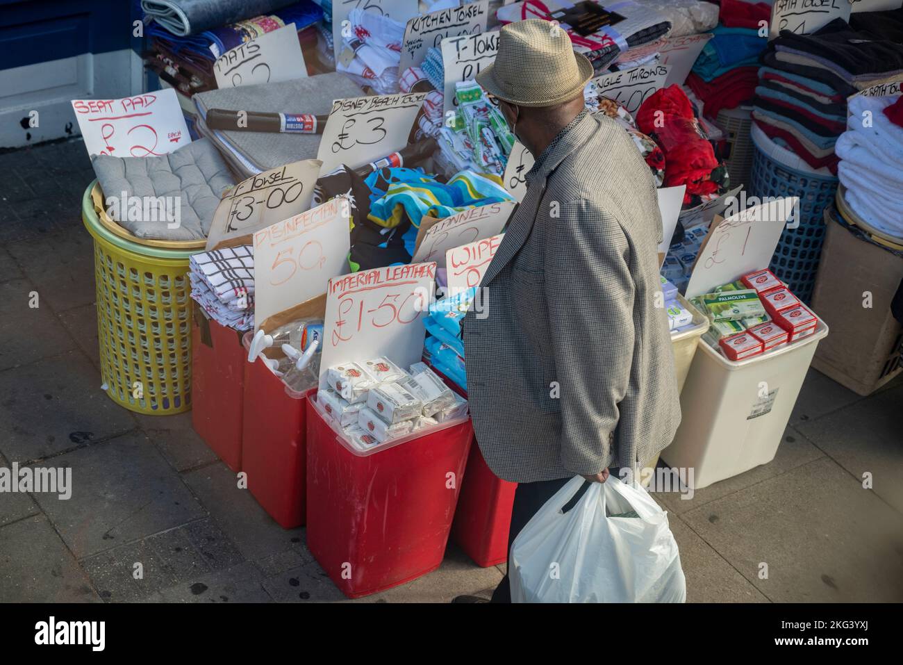 Old afro man looking at retail and cleaning products on a flea market Stock Photo