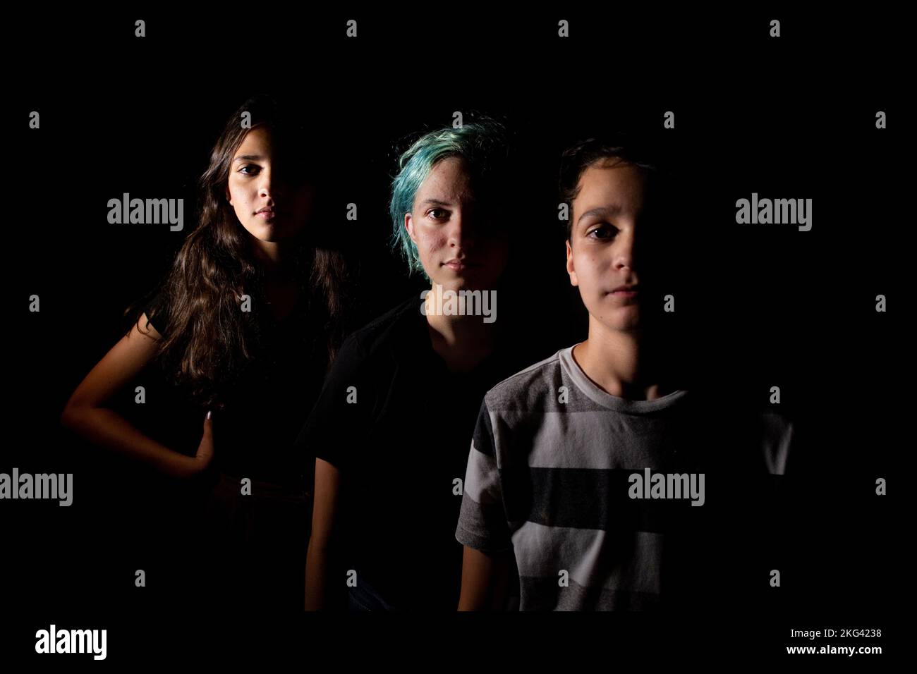 Portrait of three siblings In dramatic light Stock Photo