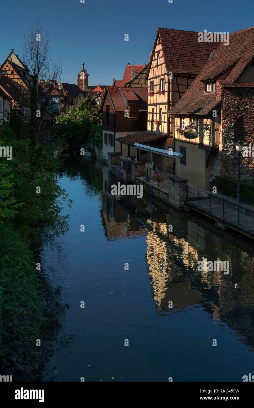 The Caveau Saint-Pierre restaurant, in a 16th century typically Alsatian timber-framed house, reflected in the rippling surface of the canalised River Lauch, which winds through the historic Little Venice (La Petite Venise) area at Colmar, Alsace, Grand Est, France. Stock Photo