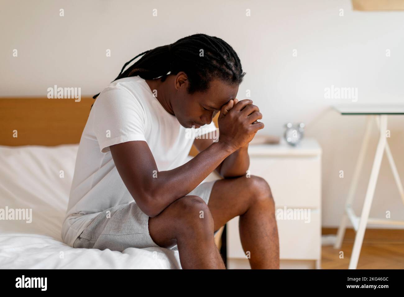 Life Problems Concept. Depressed Black Man Sitting On Bed With Head