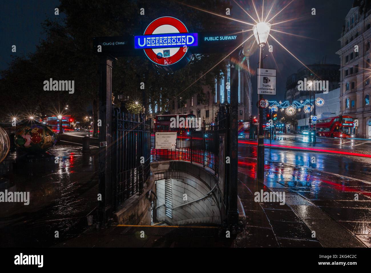 The World Reimagined project in Trafalgar Square on a rainy morning in London as light trails from the traffic add colour to the night. Stock Photo