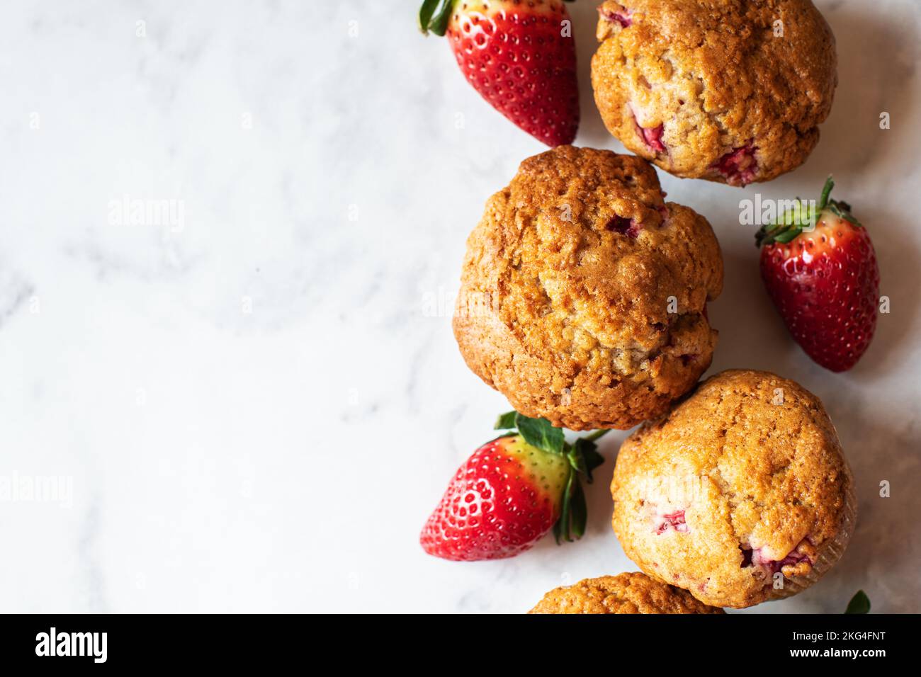 Strawberry muffins on a white marble background. Top view and copy space. Stock Photo