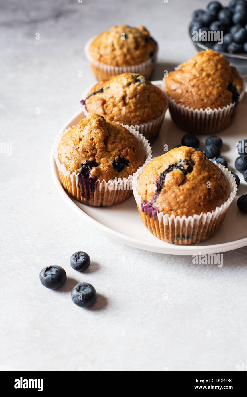 Blueberry muffins  served on a white plate on a marble background. Stock Photo