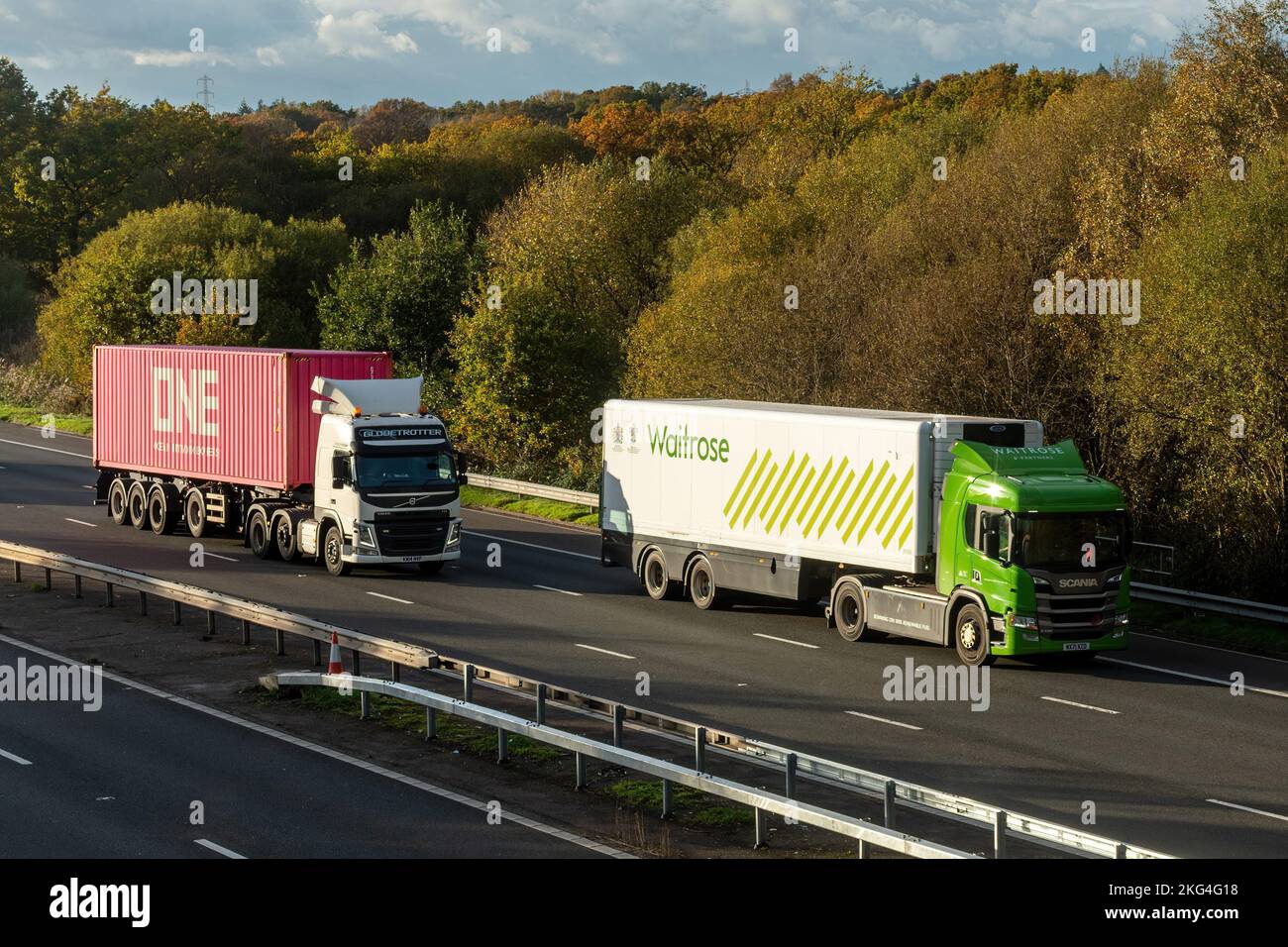 Two HGVs, Waitrose and One (Ocean Network Express) lorries travelling along the M3 motorway, England, UK Stock Photo
