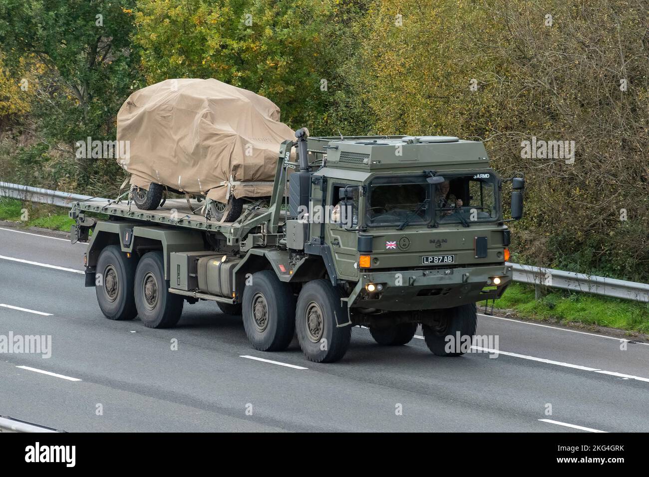 Army MAN logistics vehicle transporting another military vehicle along the M3 motorway, England, UK Stock Photo