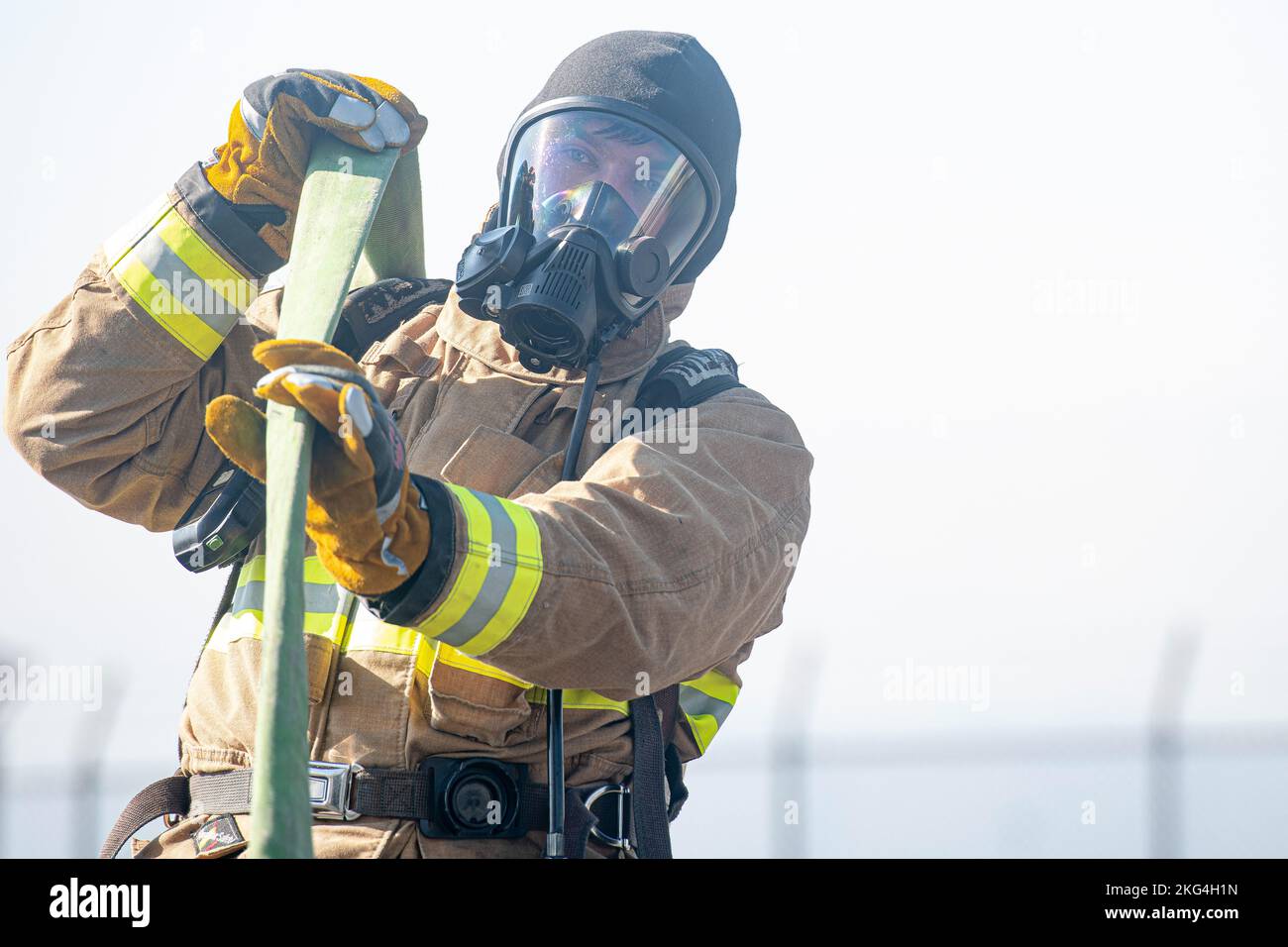 Staff Sgt. Christopher Gold, 374th Civil Engineer Squadron firefighter crew chief, wrings out a fire hose before storing it on a fire truck during a bilateral training with the Japan Air Self-Defense Force at Yokota Air Base, Japan, Oct. 28, 2022. The 374 CES and JASDF practice together annually to give both a chance to learn from each other by trying out different equipment and methods of fire prevention. Stock Photo