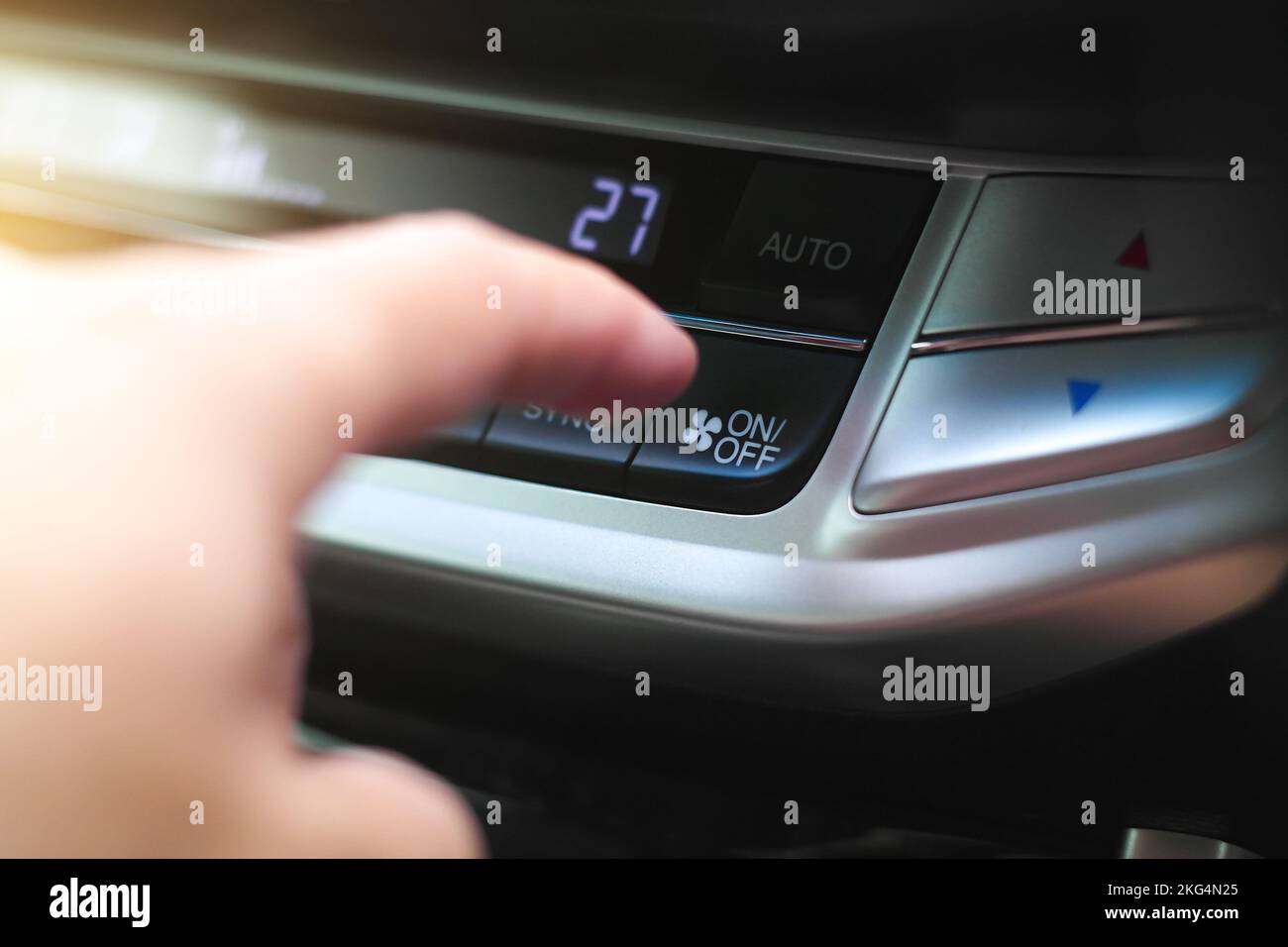 The driver hand is pressing the onoff button of the car air
