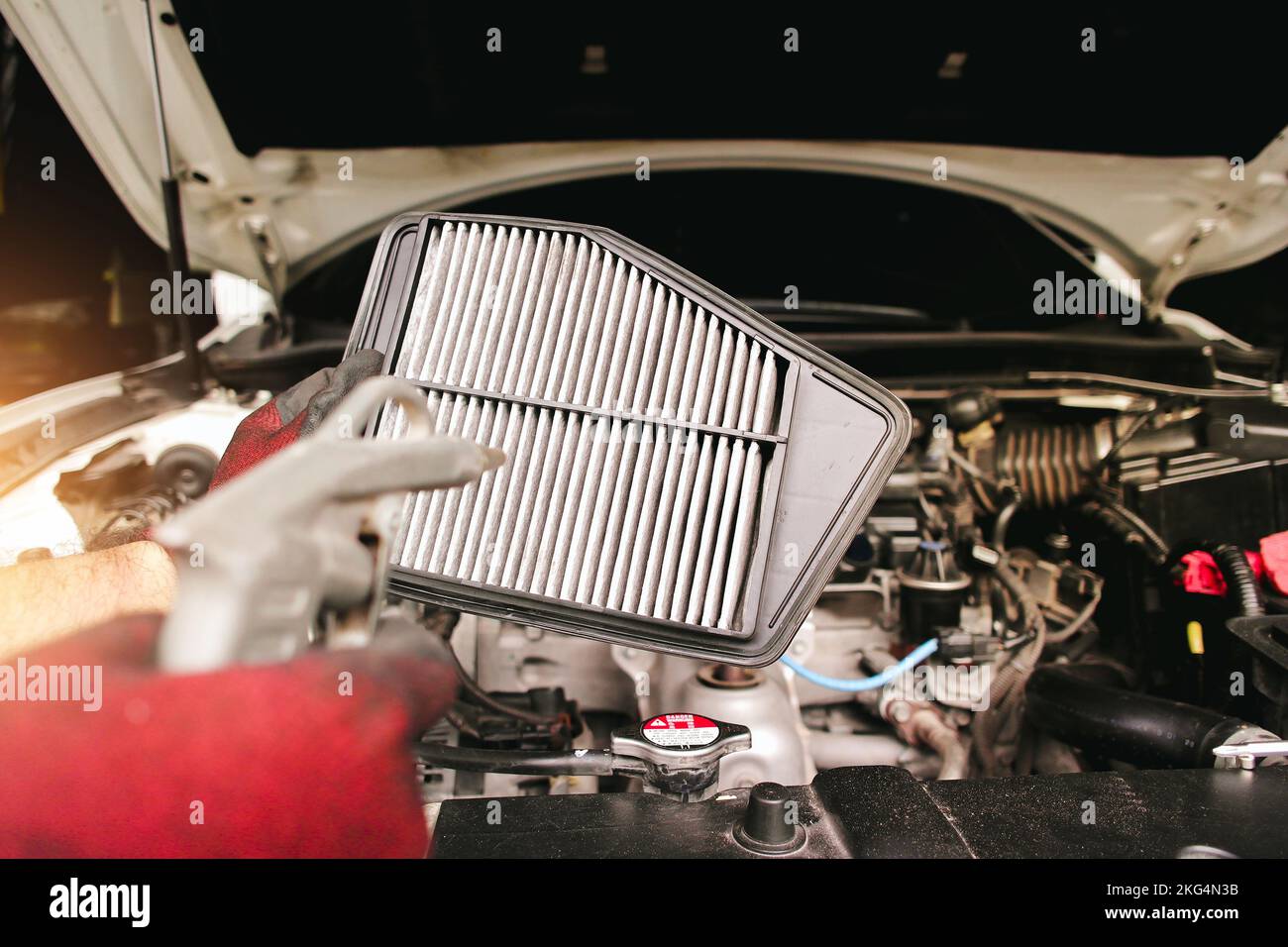 Car air filter cleaning with air blow gun by auto mechanic hand in the