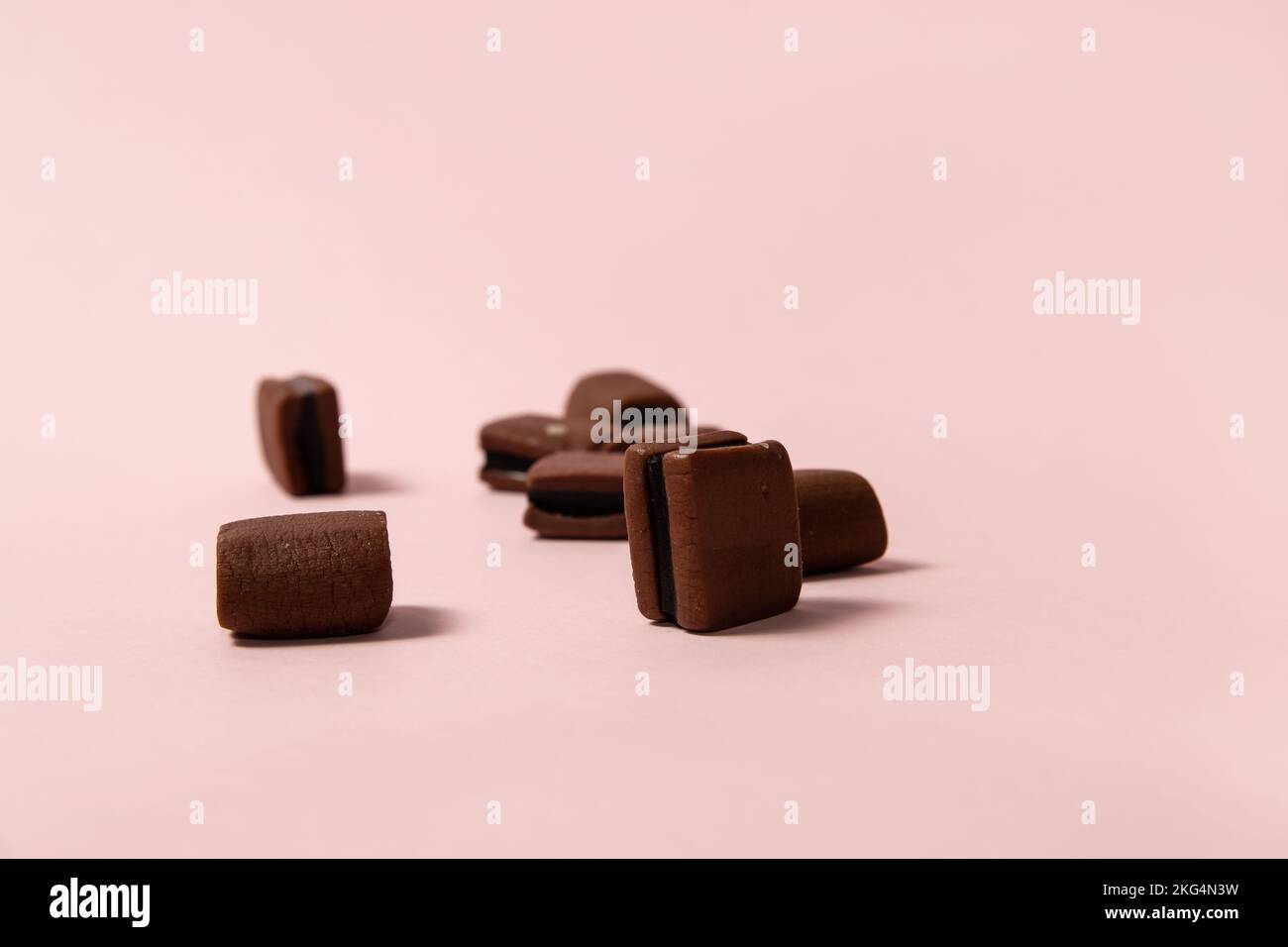 Chocolate licorice candies on pink background Stock Photo Alamy