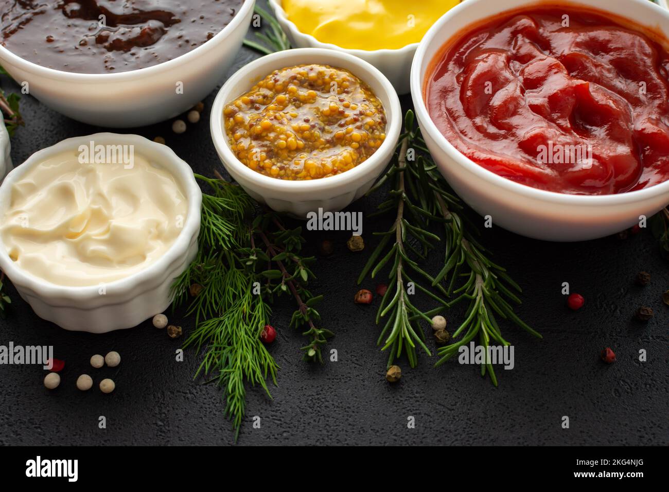 Different types of sauces in bowls with seasonings, rosemary and dill
