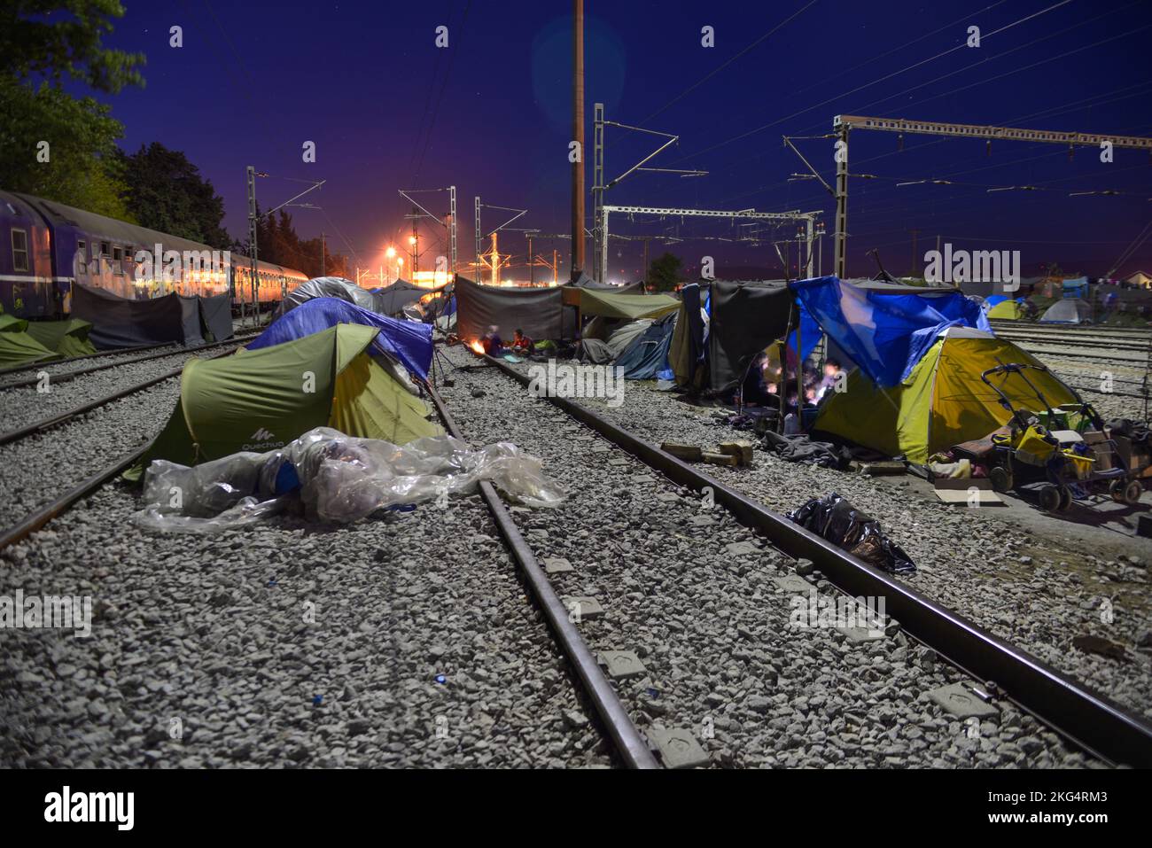 Long exposure of improvised tent city on railway tracks at night. Transit refugee/migrant camp at the Greek-North Macedonian border. Stock Photo