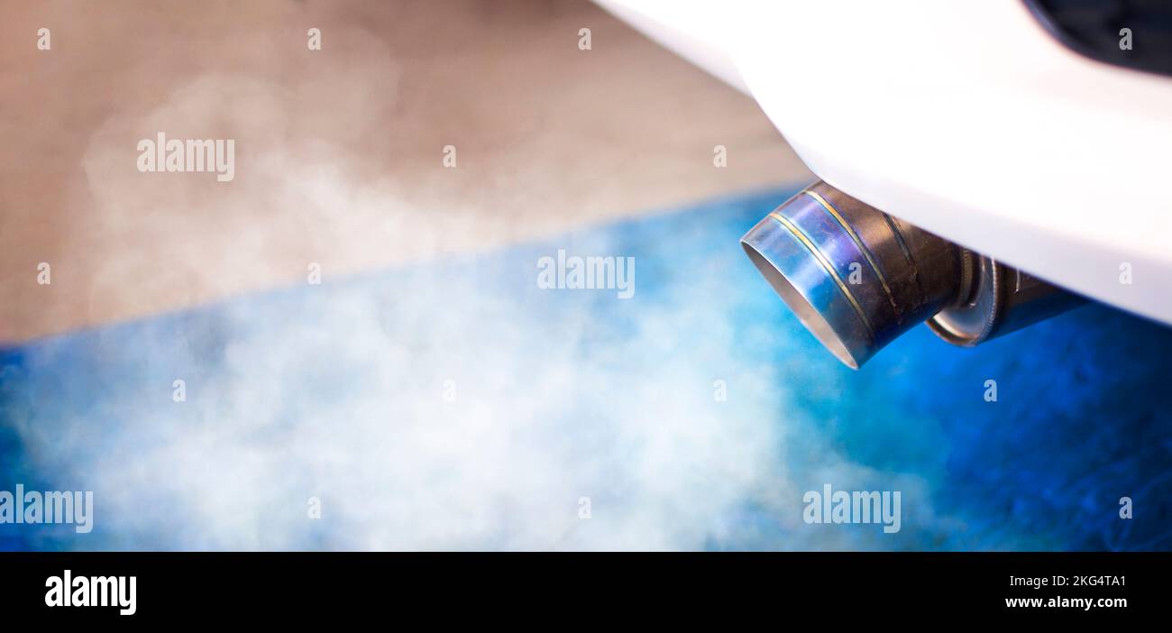 Air pollution of problem engine with white smoke , titanium car exhaust pipes on the rear bumper below of racing car Stock Photo