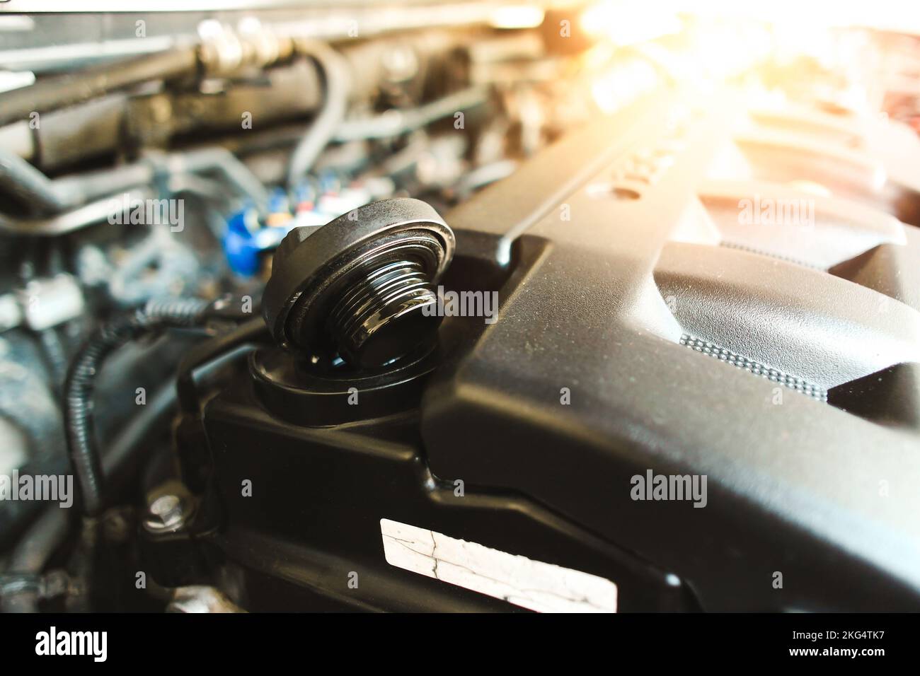 Motor oil cap of the automotive engine on plastic cover in the engine compartment , auto maintenance service concept Stock Photo