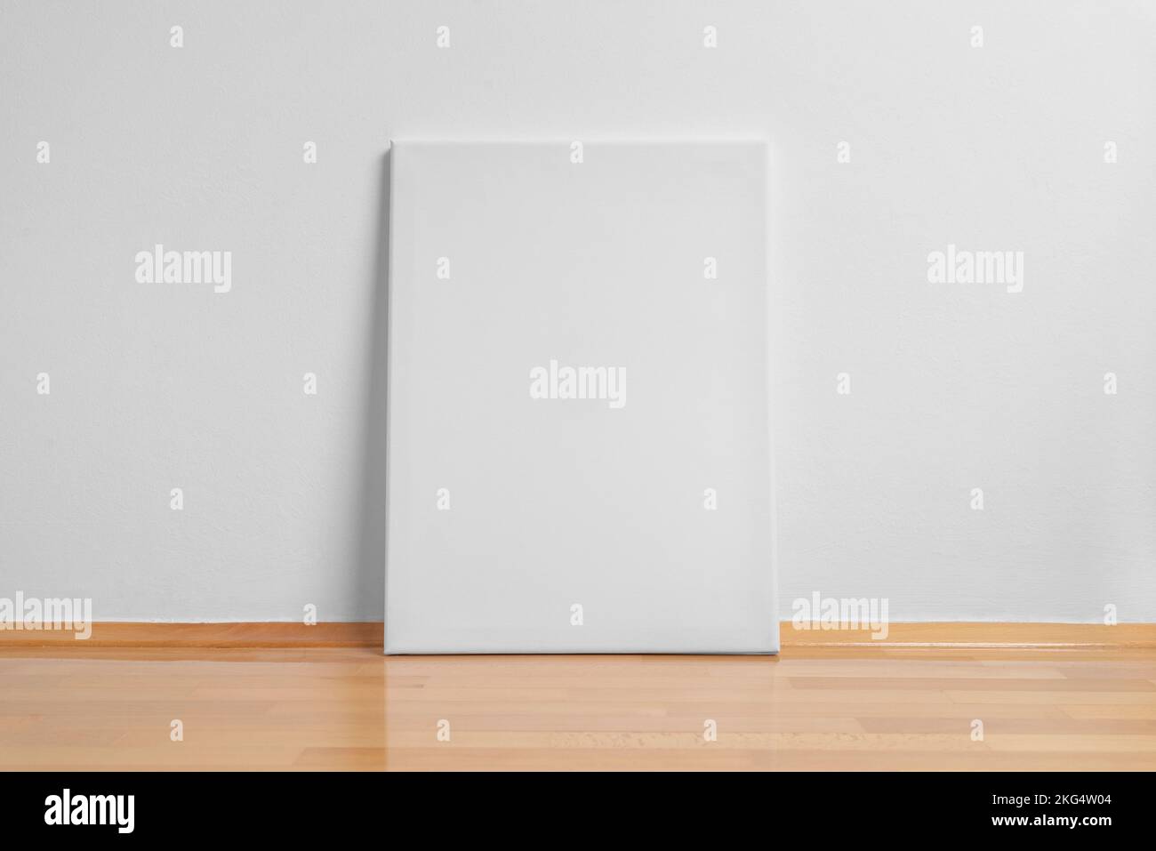 Clean art canvas leaning against a white wall. Parquet floor with reflection Stock Photo
