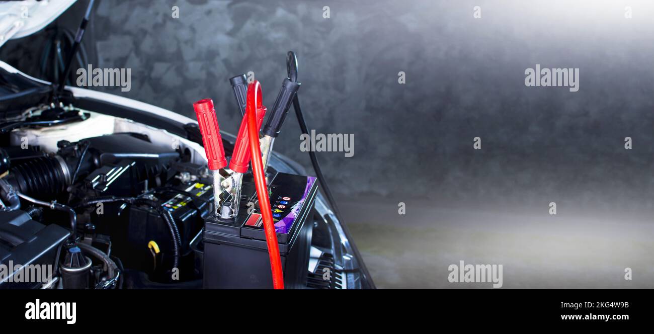 Charging the car battery in the garage, panoramic banner with copy