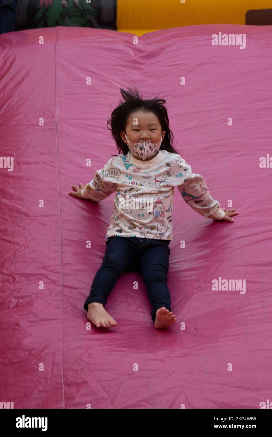 A child slides down a bounce castle during the Fuji Friendship Festival at Combined Arms Training Center Camp Fuji, Shizuoka, Japan, Oct. 29, 2022. Festival attendees were able to view static displays, listen to live entertainment, and interact with U.S. military and Japan Ground Self-Defense Force personnel. The Fuji Friendship Festival is one of many events Marine Corps Installations Pacific organizes across the Pacific to strengthen the Japan-U.S. alliance and showcase Marine Corps capabilities to host nation residents. Stock Photo