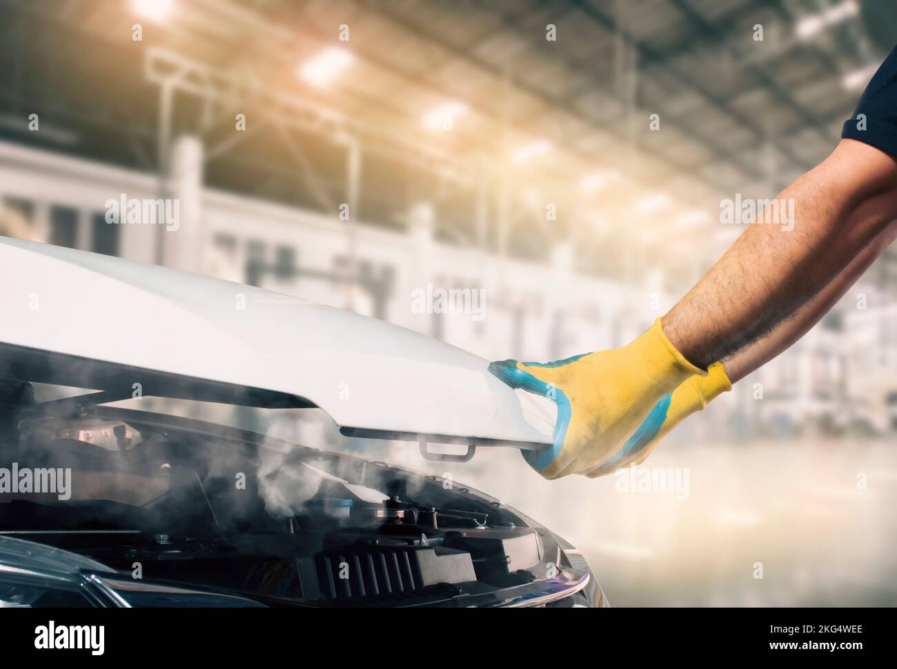 The mechanic opened the hood of the broken car and smoke came from