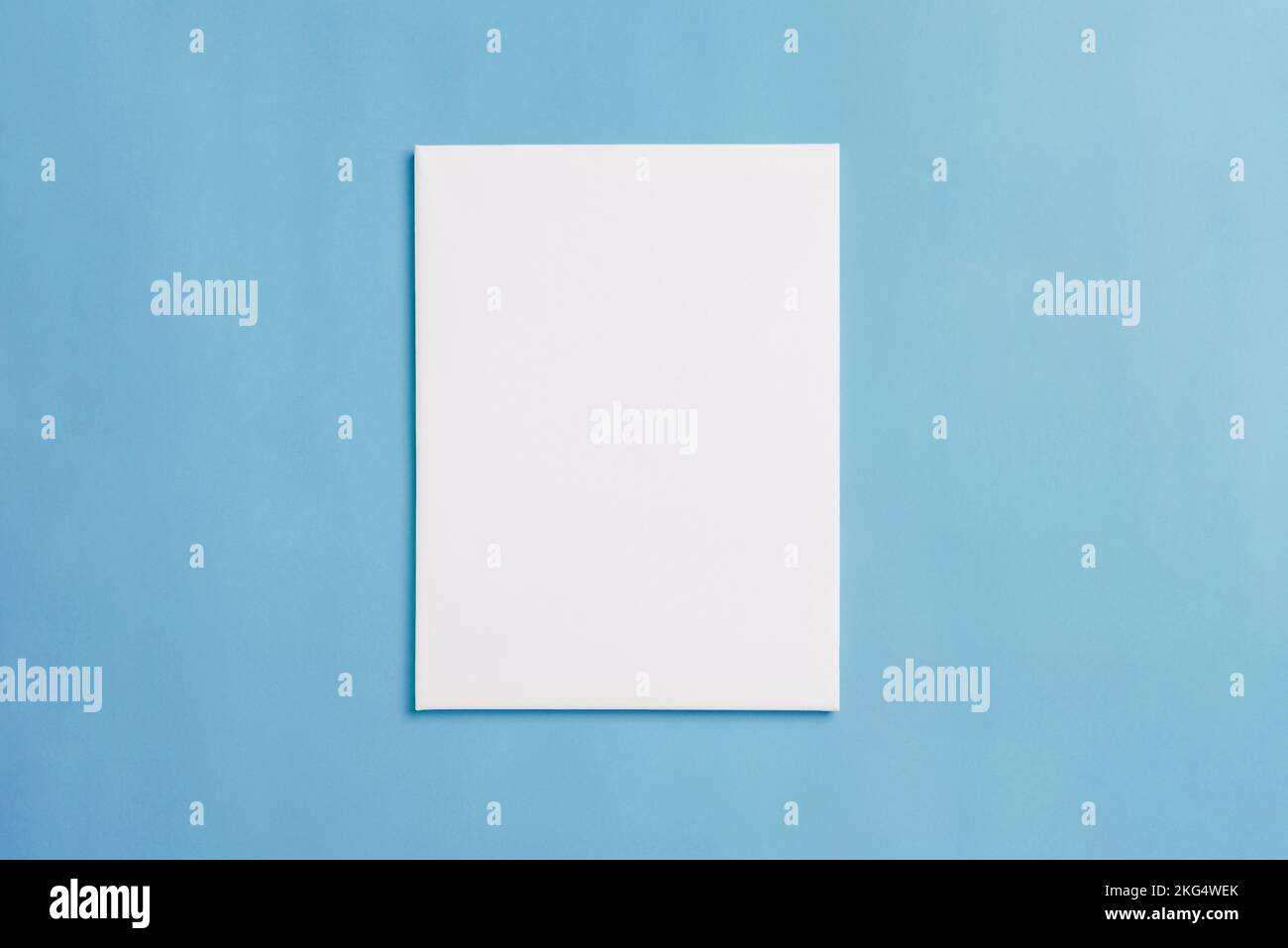 Empty white canvas on blue floor for painting presentation. Top view, flat lay Stock Photo