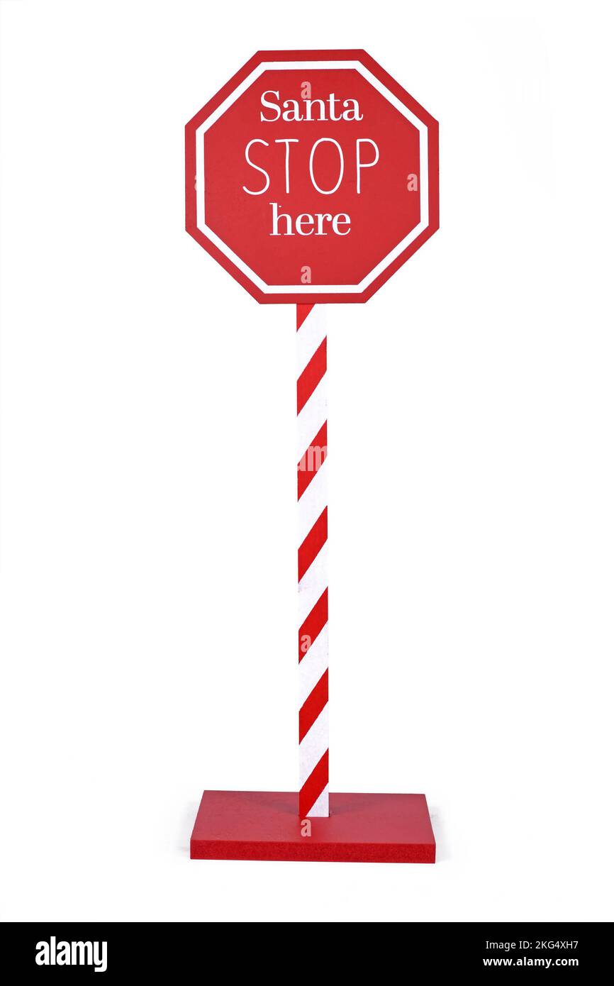 Red Christmas sign with text 'Santa Stop here' on white background Stock Photo