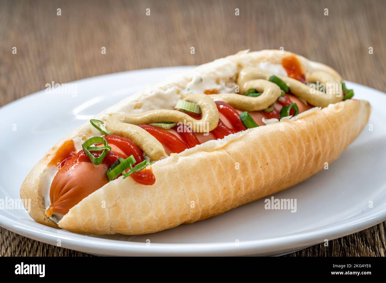 hot dog with mustard ketchup and spring onion Stock Photo