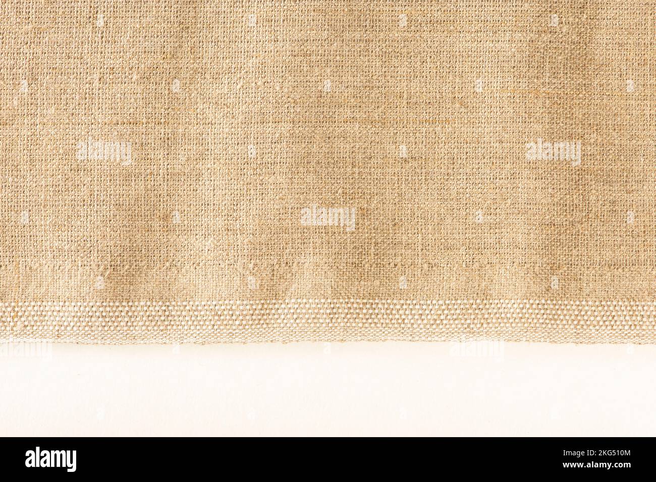 Texture of linen fabric. Natural linen fabric with a finished edge on a white background Stock
