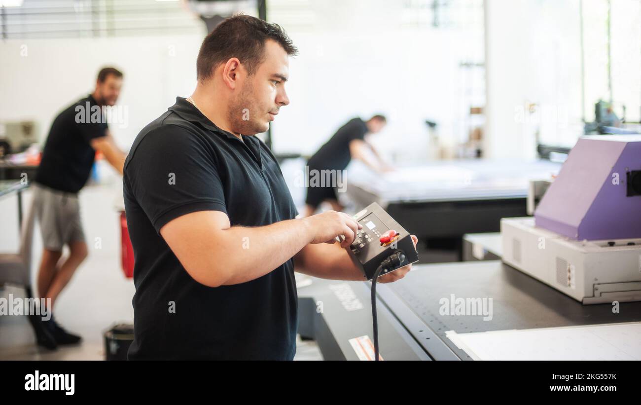 Professional worker printmaker technician operator works in printing