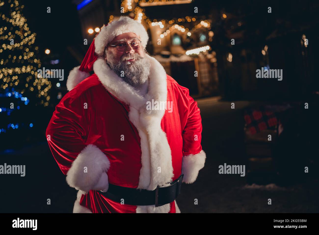 Photo of positive joyful funky retired old man santa claus wear red coat stand own house home lapland village residence outdoors Stock Photo
