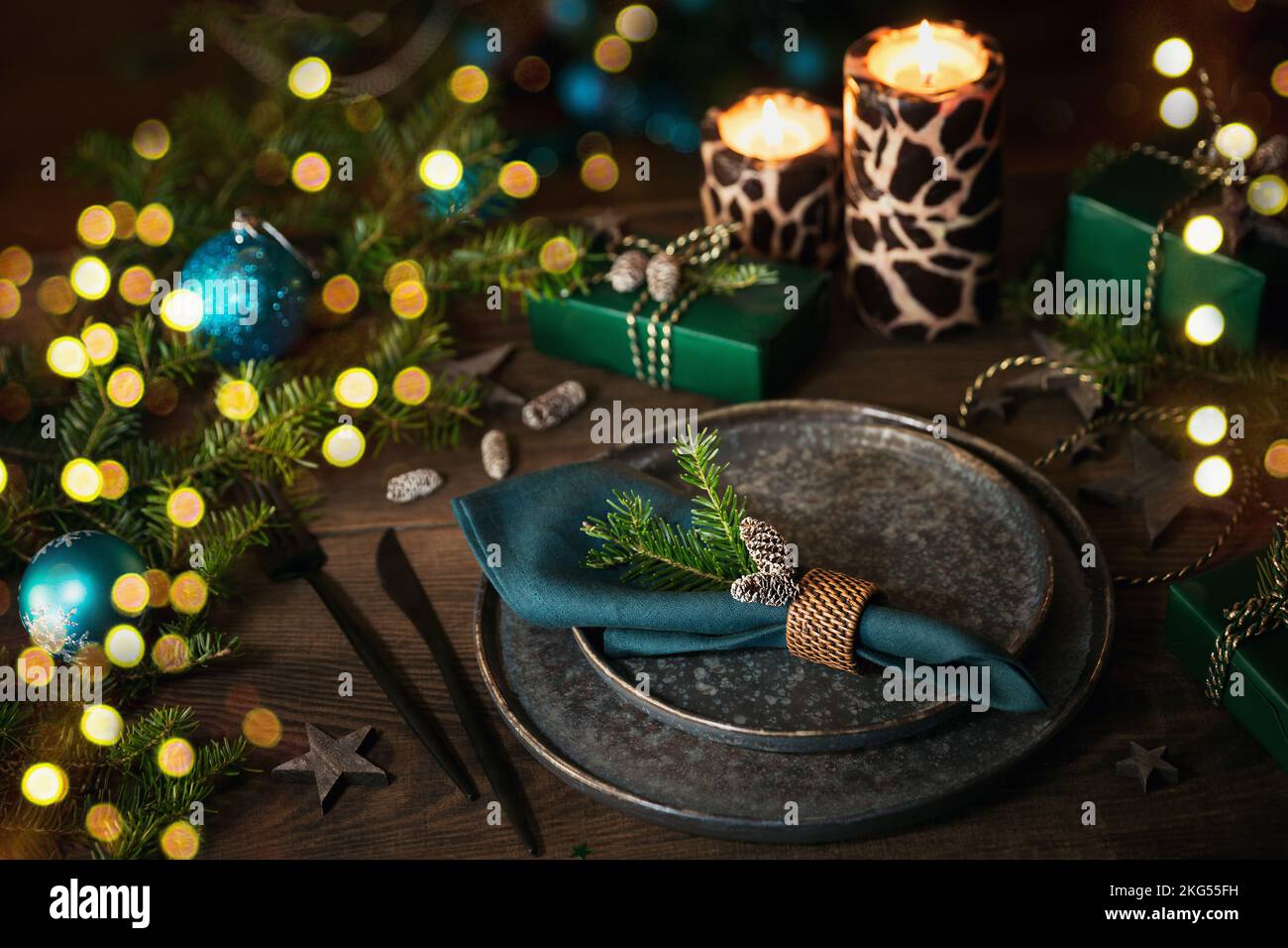 Christmas table setting with empty black ceramic plate and green gift ...