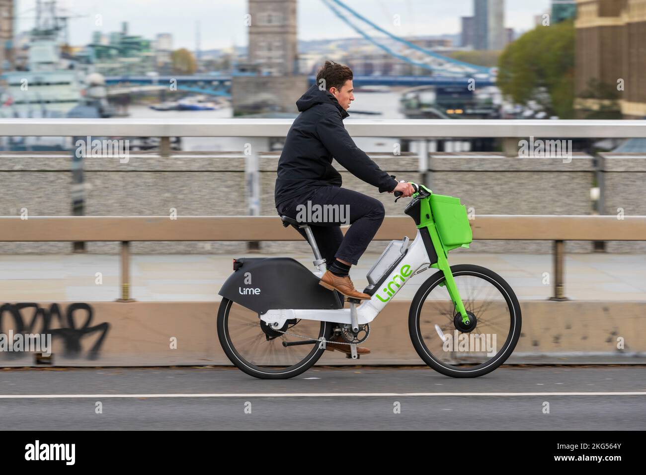 A man commuting on a Lime electric hire bike across London Bridge