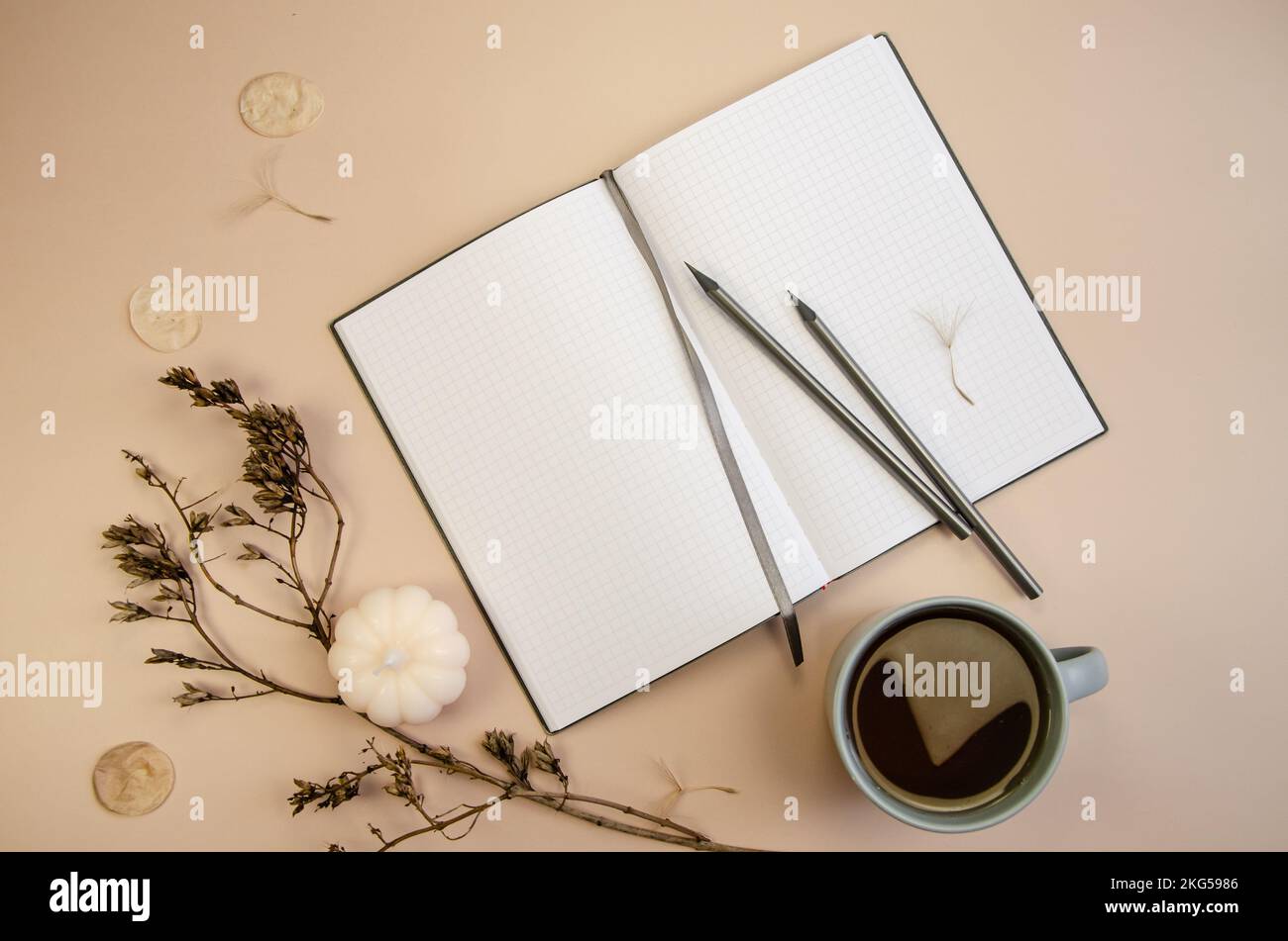 Notepad copyspace, gray pencils and cup of coffee on tan begie ...