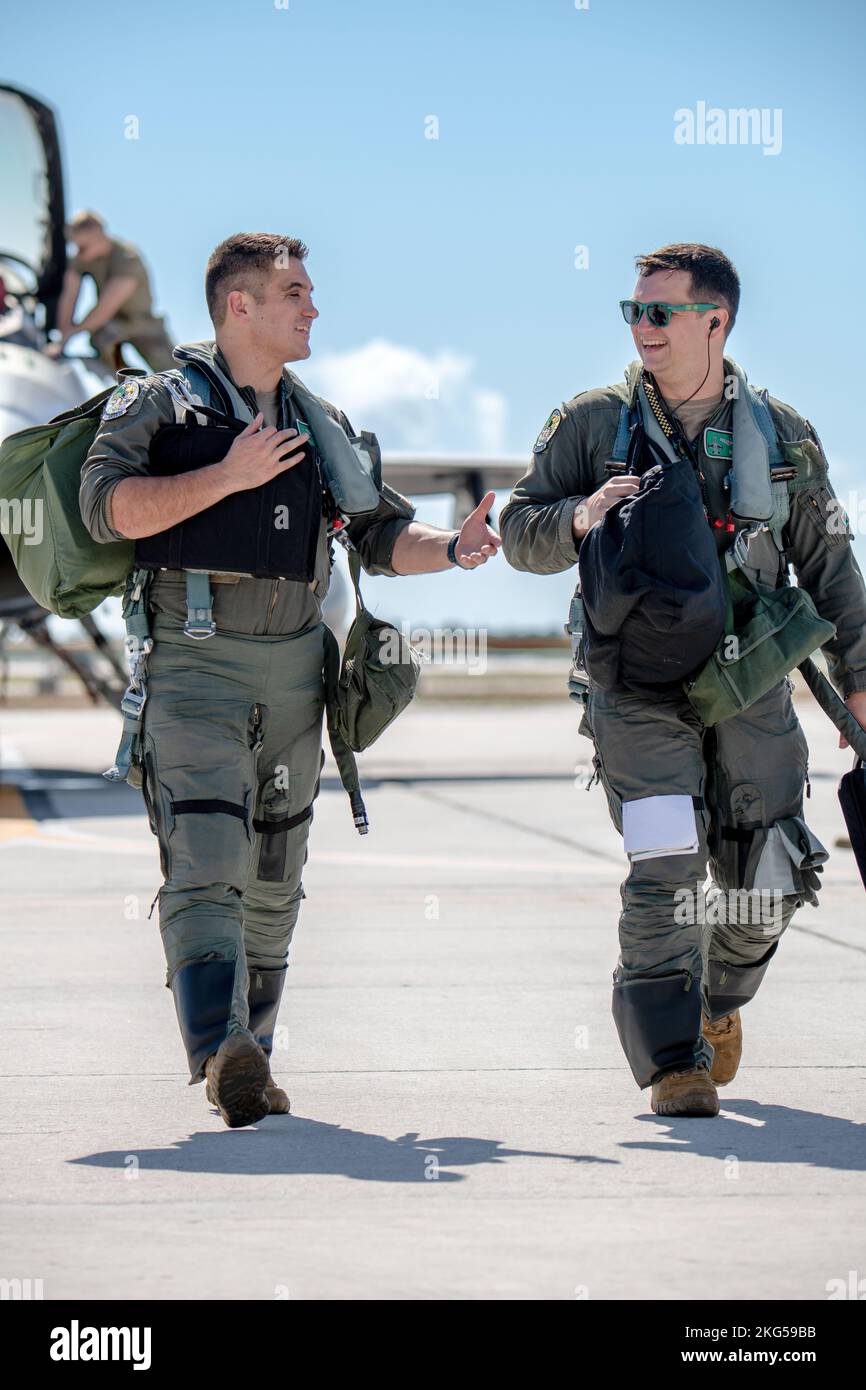 U.S. Air Force Maj. Brannen Studley and U.S. Air Force 1st Lt. Daniel Abner, F-16 fighter pilots assigned to the Ohio National Guard's 180th Fighter Wing, talk about the training flight they just completed at Naval Air Station Key West, Florida, Oct. 31, 2022. The 180FW deployed to Key West to train with VFC-111, the Navy's premier adversary squadron, providing realistic training scenarios that ensure the 180FW is prepared for homeland defense and contingency operations around the globe. Stock Photo