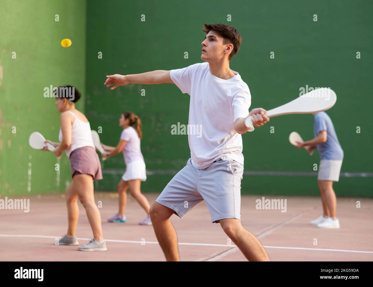 Young male pelota player hitting ball with wooden racket Stock Photo ...
