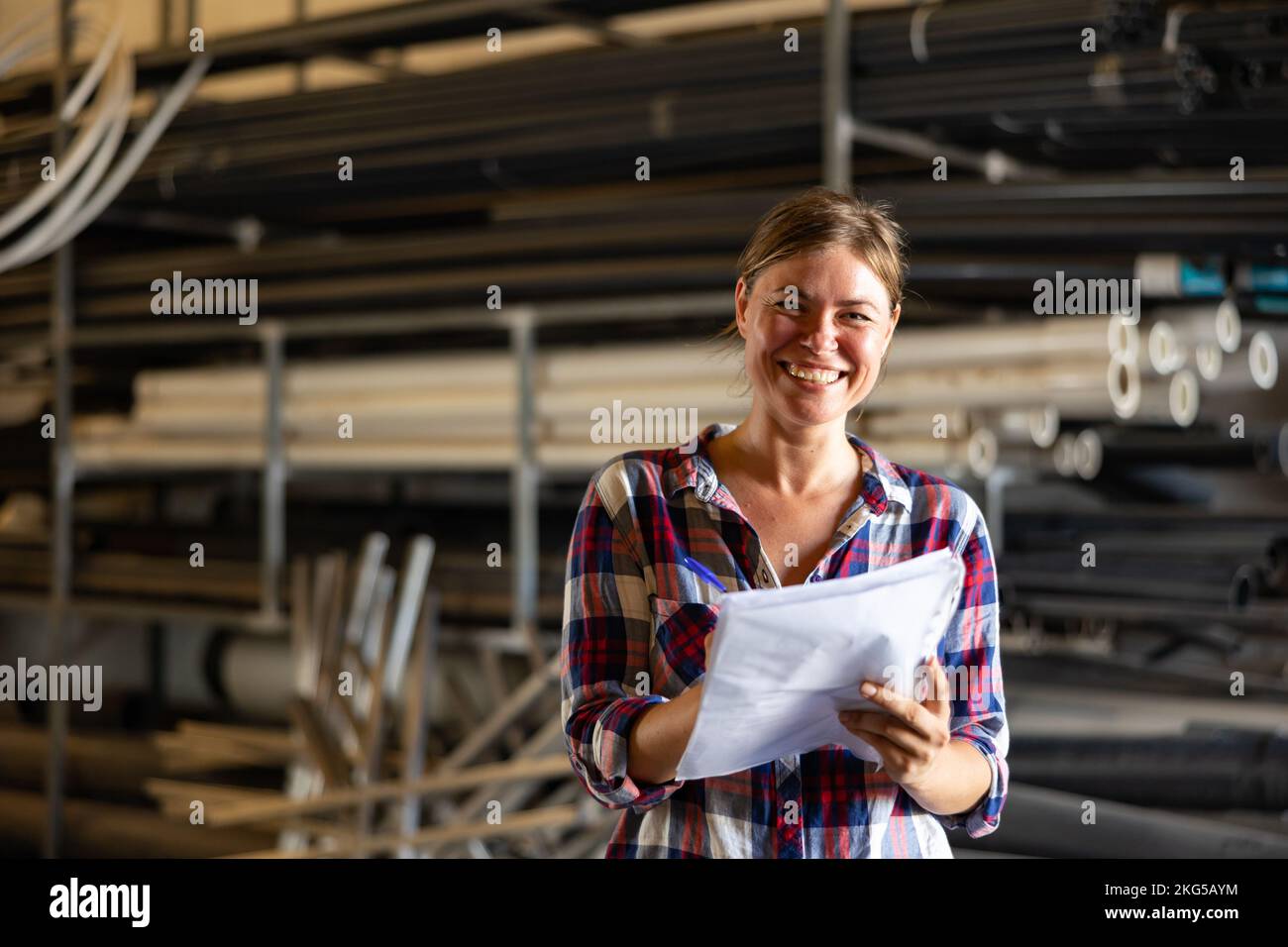 Joyful woman inspecting warehouse Stock Photo