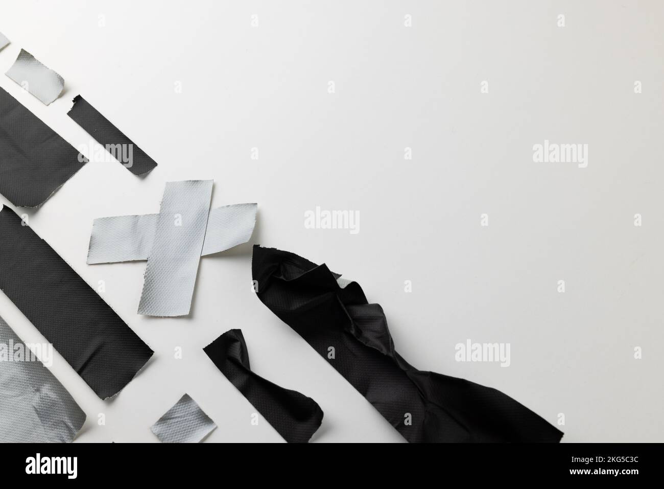 Pieces of black and grey masking tape and grey masking tape cross on