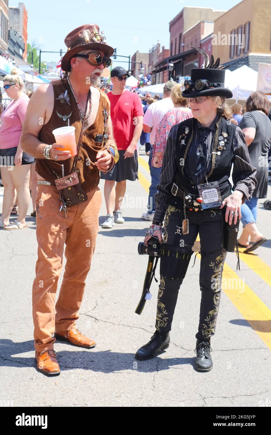 A man and a woman dressed up in steampunk costumes standing and talking in the street surrounded by people at a festival in Van Buren Arkansas a4 28 2 Stock Photo