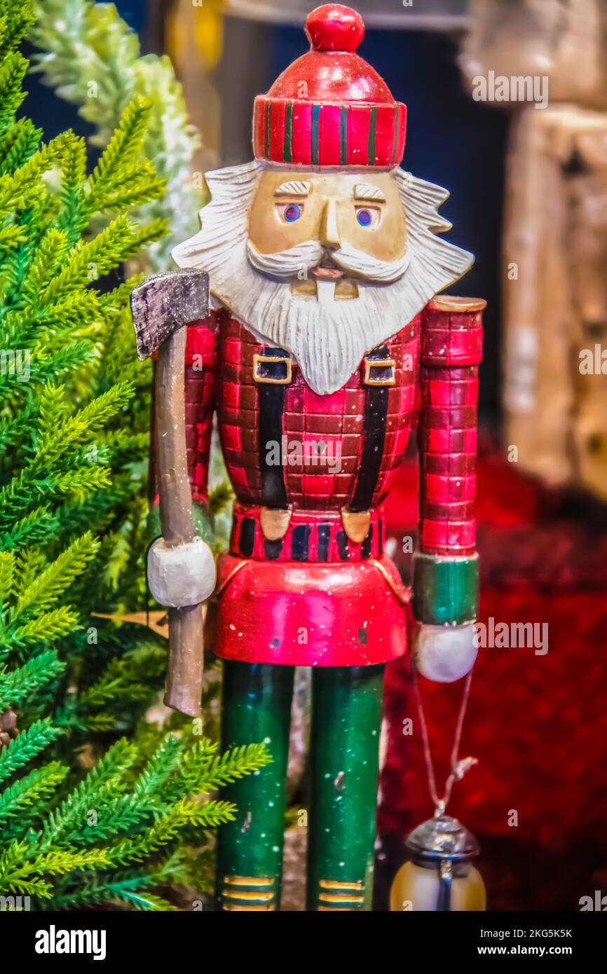 Lumberjack santa nutcracker carved out of wood beside toy tree with ax and lantern - Selective focus Stock Photo