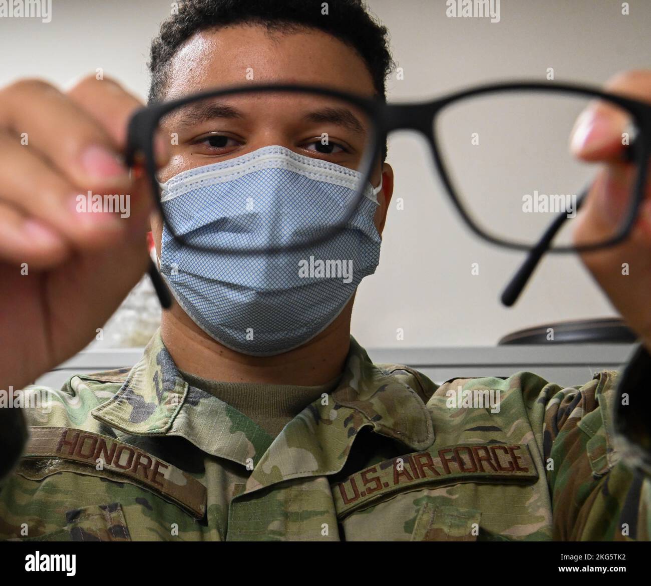 U.S. Air Force Senior Airman Kyree Honore, 509th Medical Group, Optometry Technician looks through the lens of glasses the optometry office has to offer at Whiteman Air Force Base, Missouri, October 5, 2022. Tricare provides two free pairs of glasses to active duty Airmen annually. Stock Photo