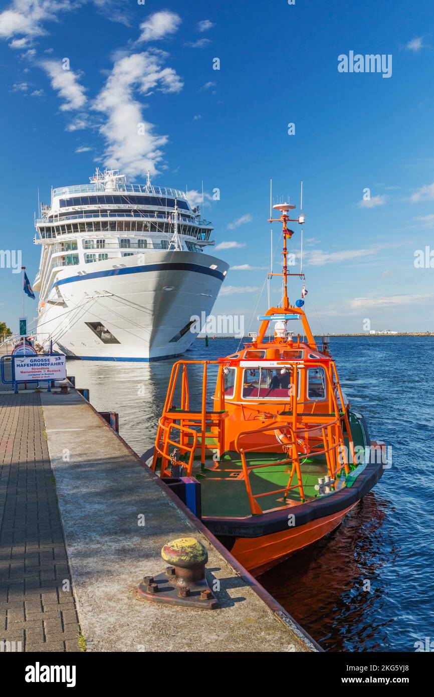 Orange tugboat and white and blue cruise ship moored at dock, Port of ...