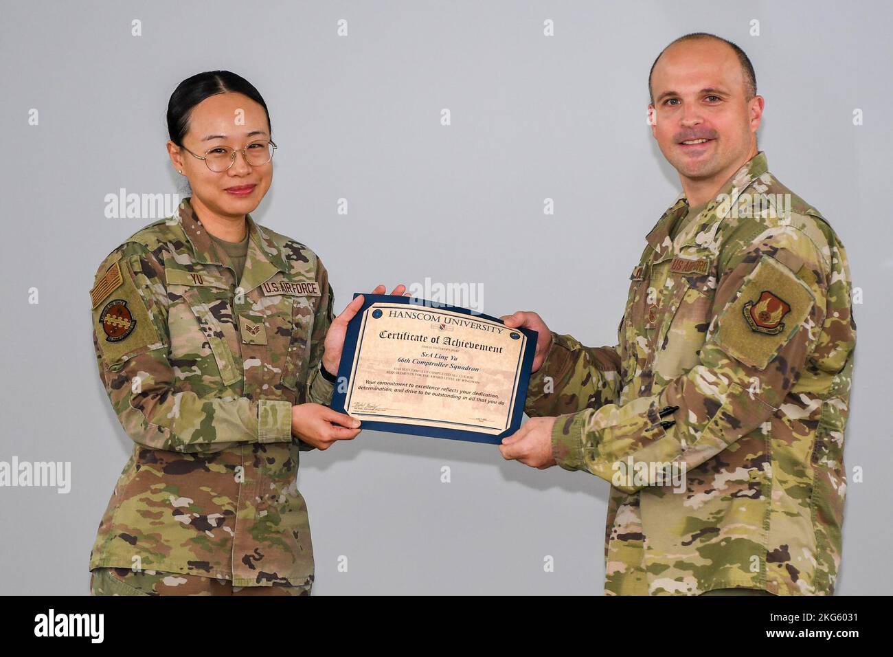 Master Sgt. Michael Kennedy, Hanscom career assistance advisor, presents Senior Airman Ling Yu, 66th Comptroller Squadron financial analyst, with a Hanscom University certificate of achievement at Hanscom Air Force Base, Mass., Oct 6. Yu received a certificate for completed courses at Hanscom University to earn her Wingman Level.  To achieve Wingman Level, Yu completed four core, one intermediate and one advanced class, as well as a course project. Stock Photo