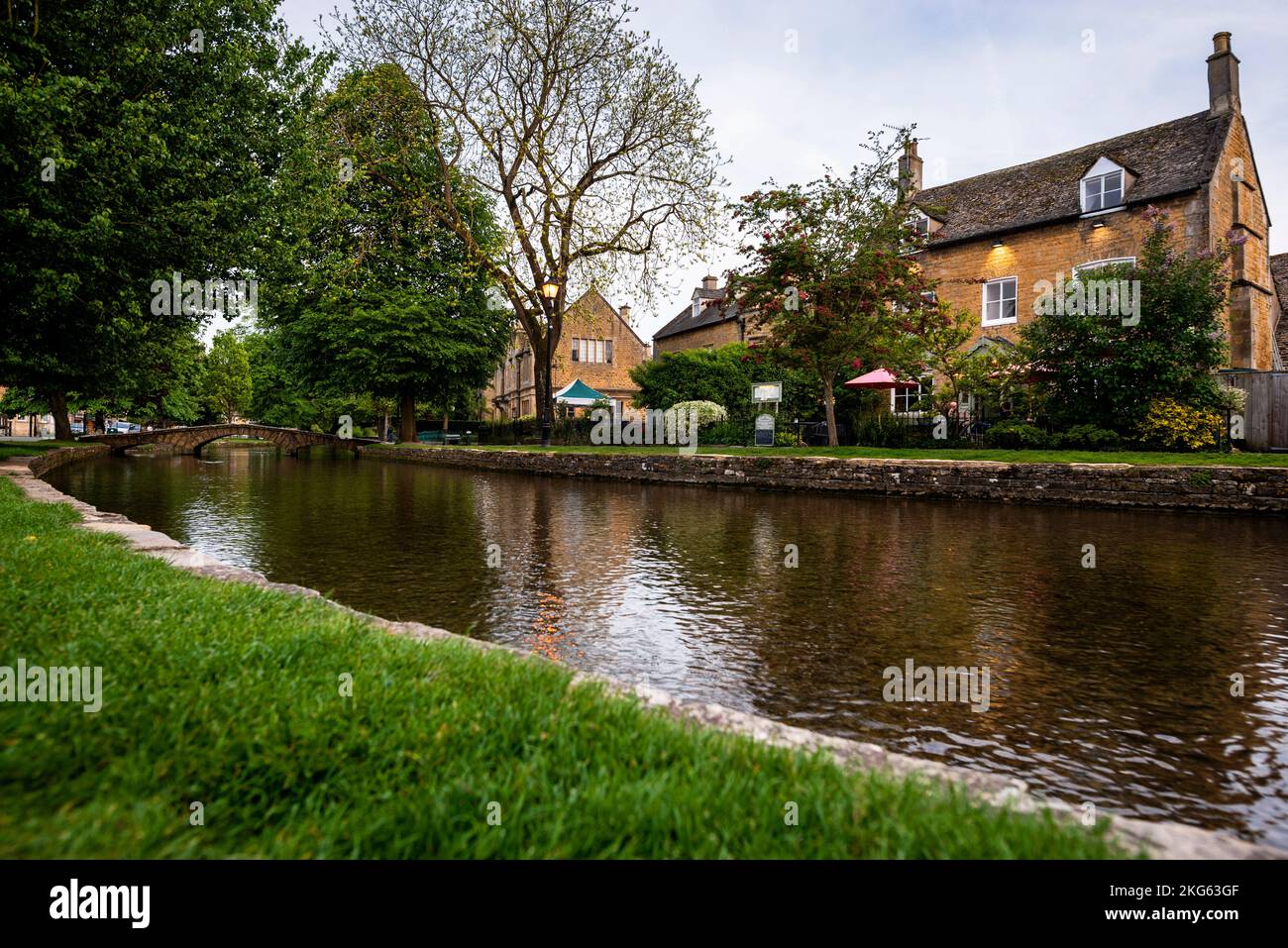 River Windrush and low arched stone pedestrian bridges in Bourton-on-the-Water in the Cotswolds, England. Stock Photo