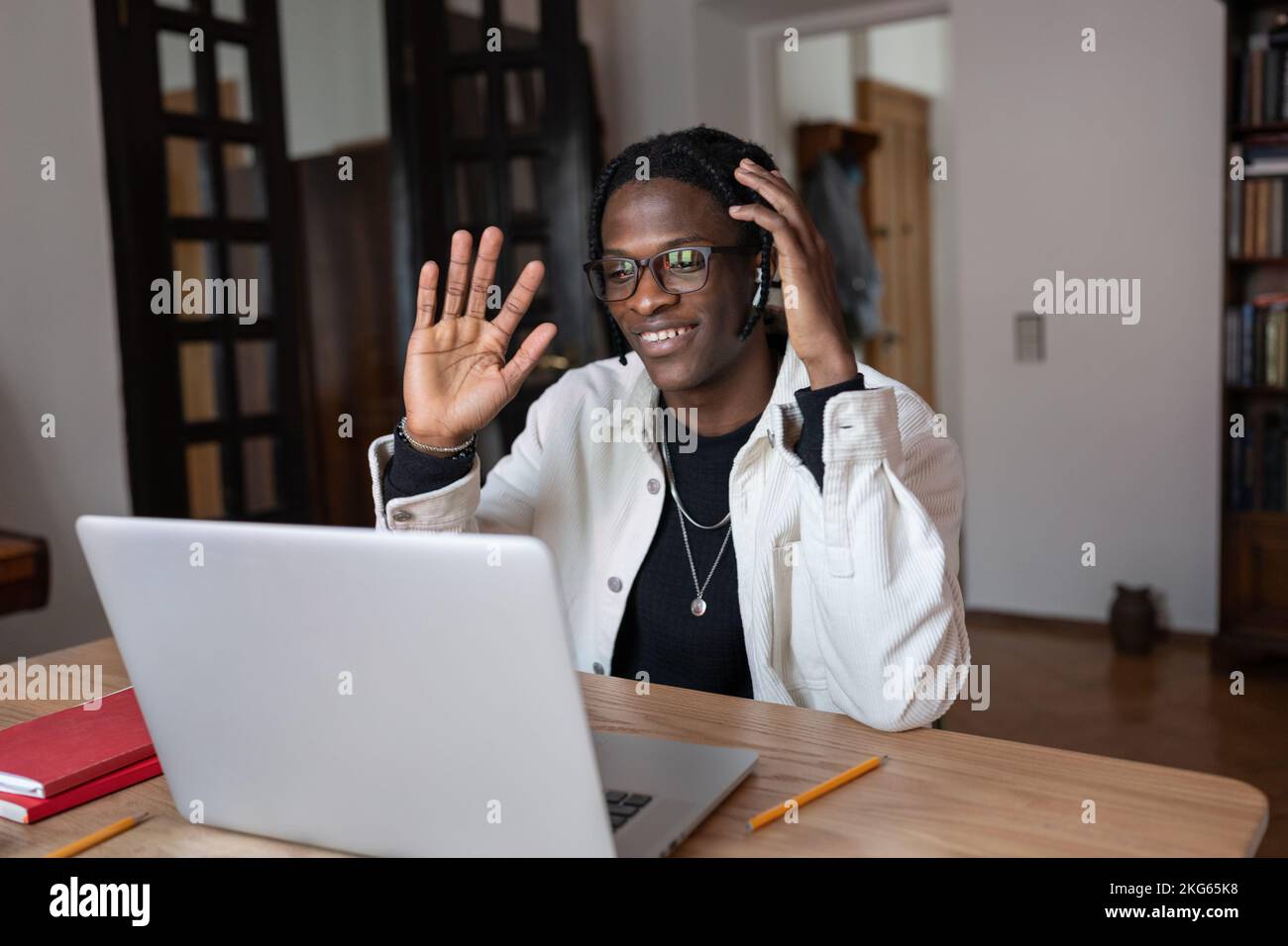 Smiling optimistic African American man waving hand having video call ...