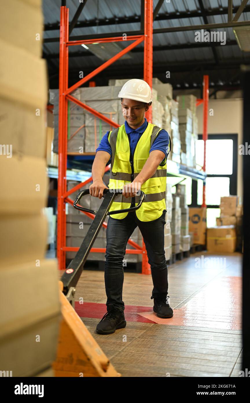 Portrait, Determined and professional millennial Asian male warehouse worker in uniform pulling