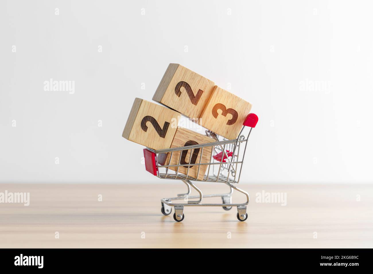 Happy new year with 2023 block in shopping trolley cart on table. E commerce, online shopping, finance, consumer economy and celebration concepts Stock Photo