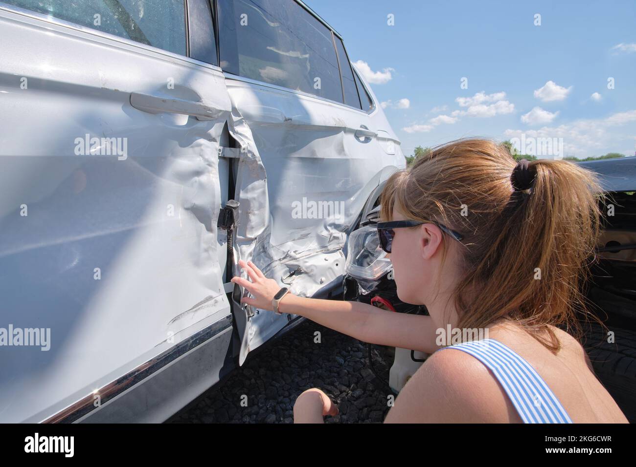 Sad female driver sitting on street side shocked after car accident ...