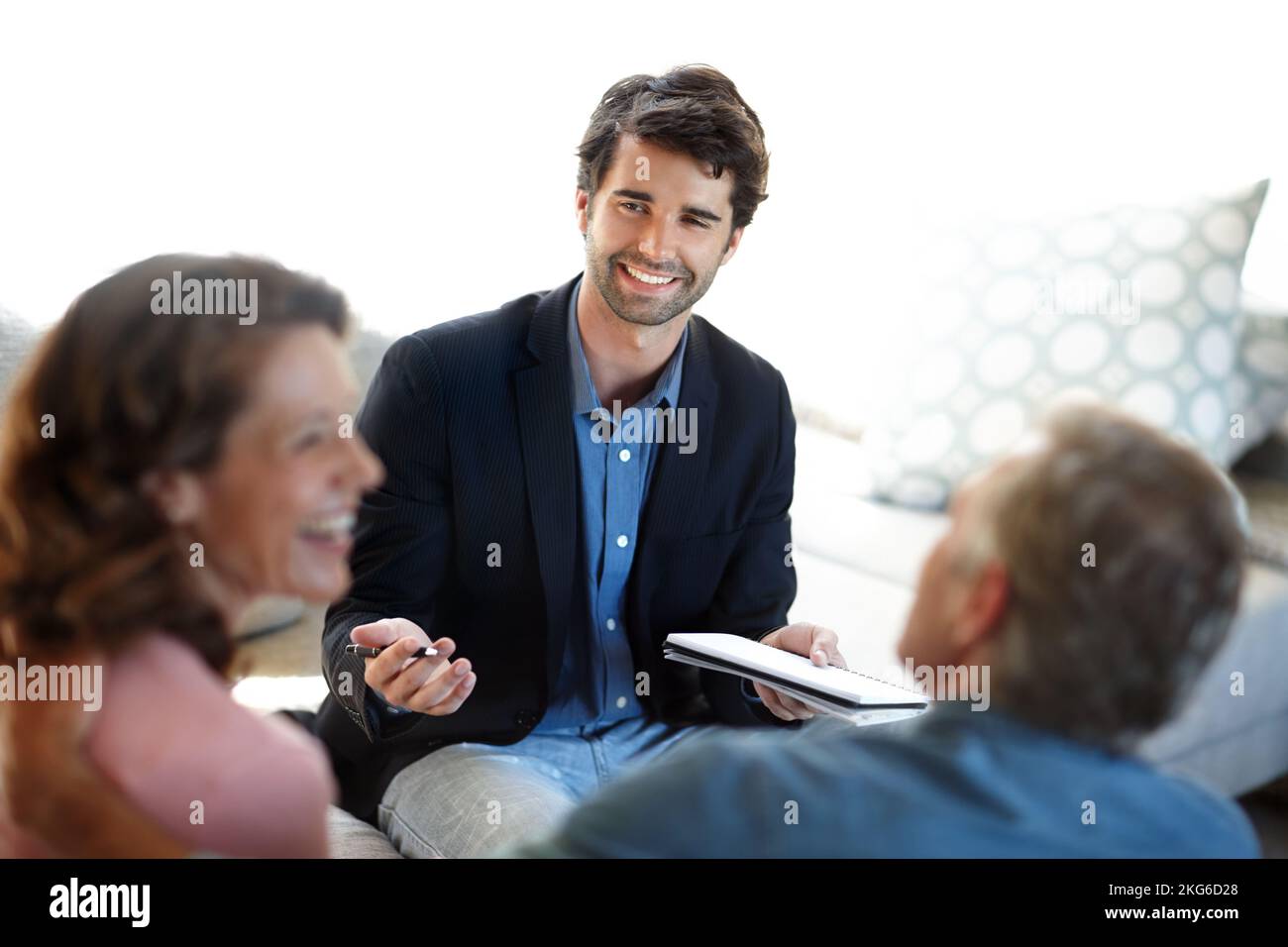 Sharing good news about their investments. A young consultant giving advice to a mature couple. Stock Photo