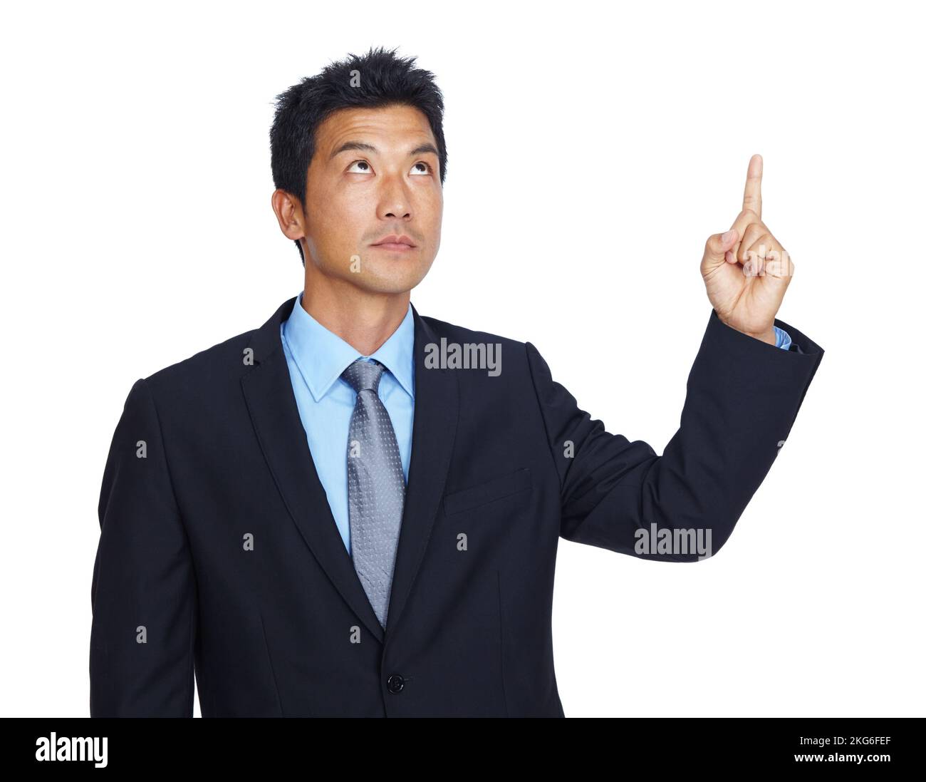 Let me think about that...An isolated shot of a serious young businessman looking and pointing upwards. Stock Photo