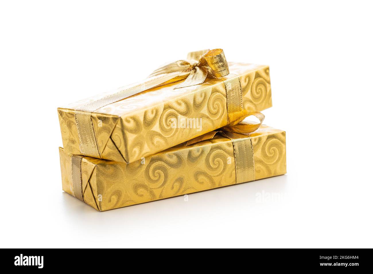 Gift wrapped in gold foil. Christmas present with gold ribbon isolated